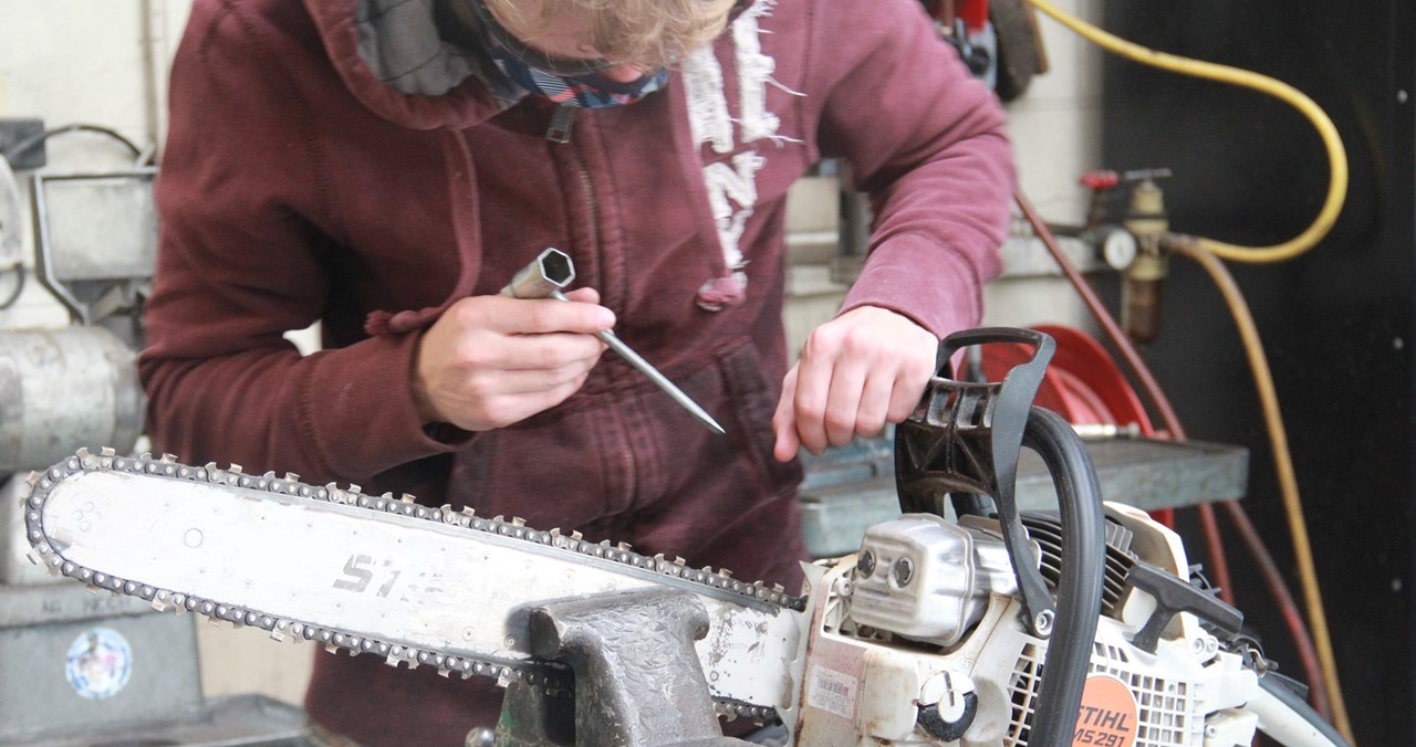 EOR student working on a chainsaw