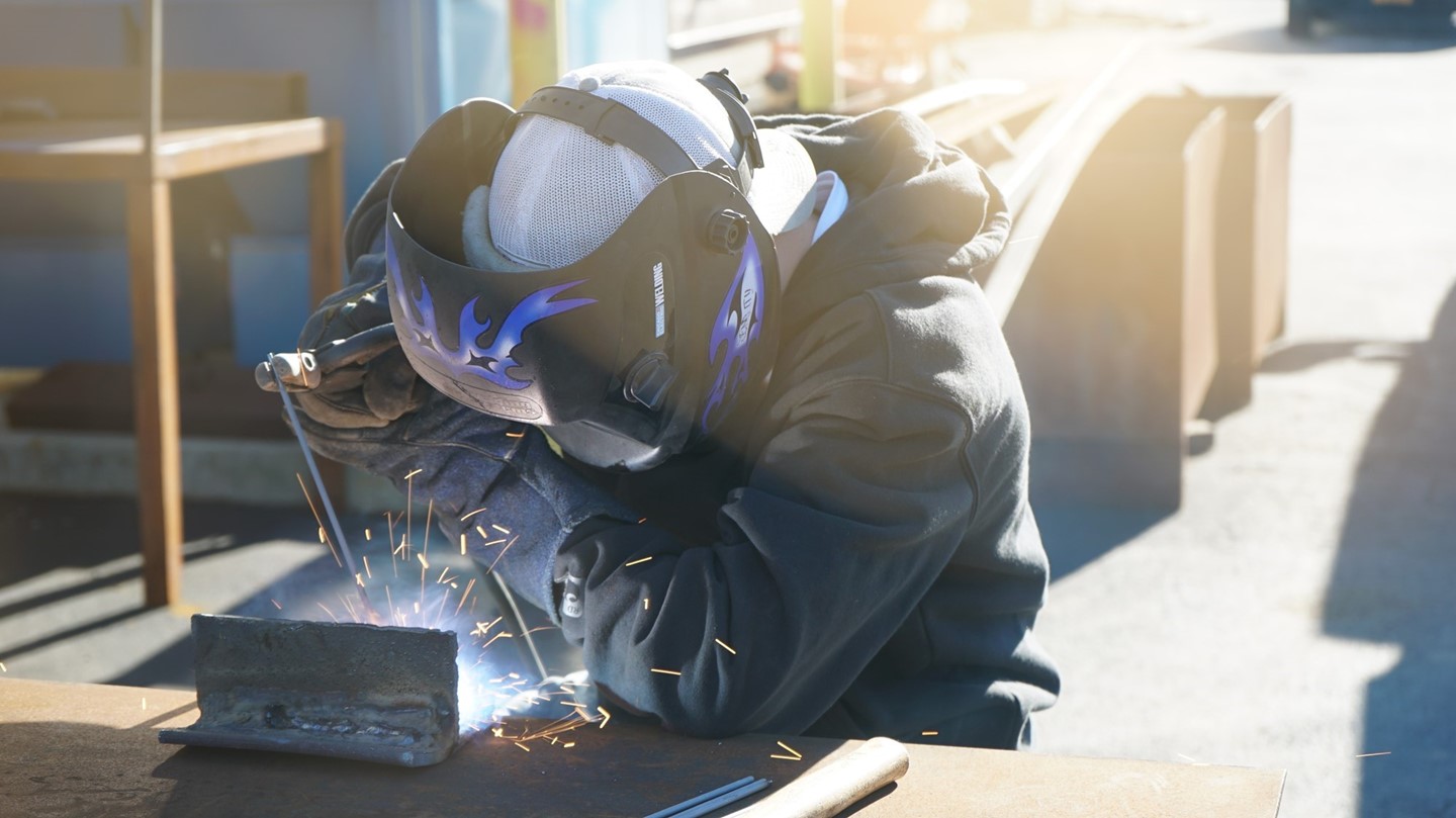 Student welding metal